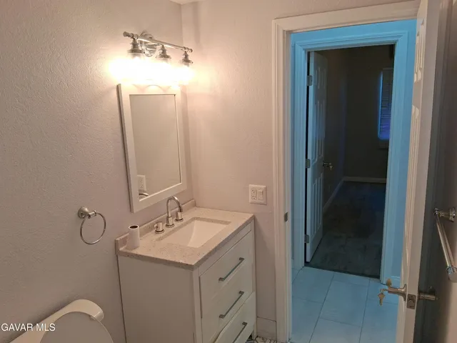 a bathroom with a sink a toilet and mirror