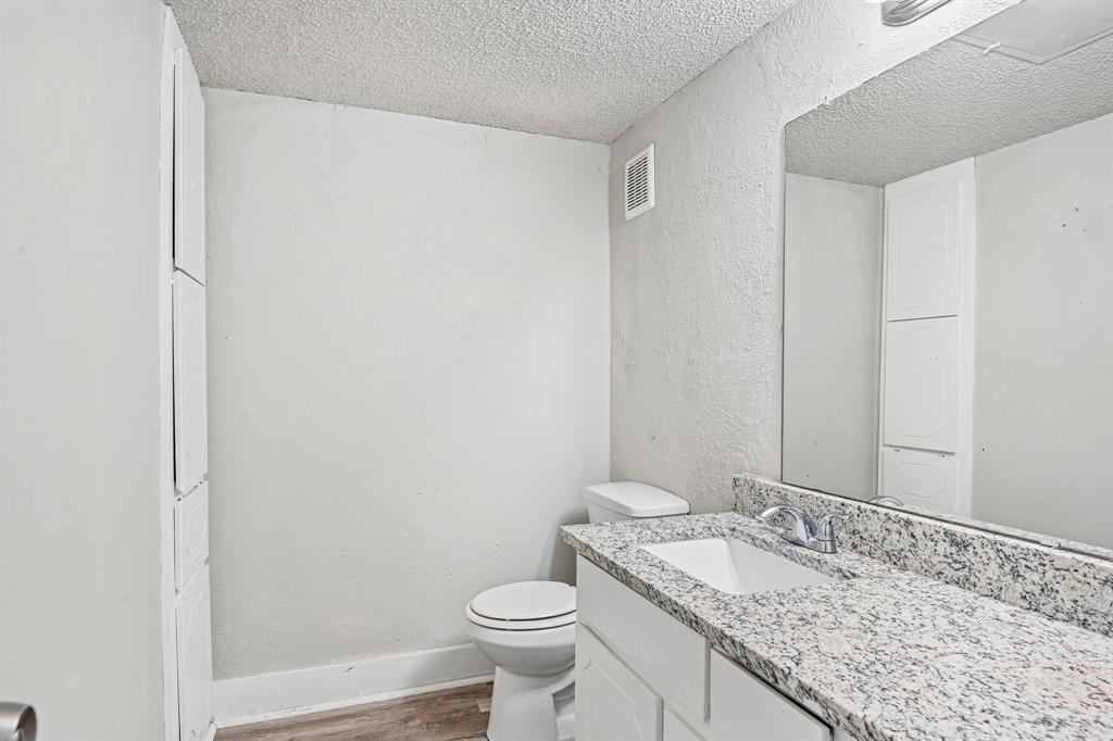 5534 Boca Raton Boulevard, Unit 292 Fort Worth, TX 76112 - Photo 14 of 31 a bathroom with a granite countertop sink and a toilet