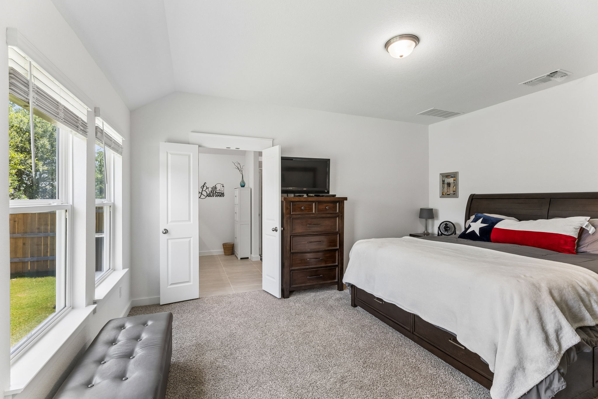 13509 Barn Chime Street Elgin, TX 78621 - Photo 19 of 40 Carpeted bedroom with vaulted ceiling and a flush-mount ceiling light fixture