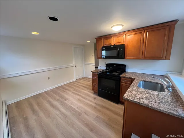 a kitchen with granite countertop a refrigerator stove and sink