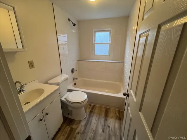 a bathroom with a sink a toilet a tub and shower