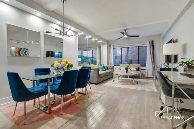 a living room with furniture kitchen view and a wooden floor