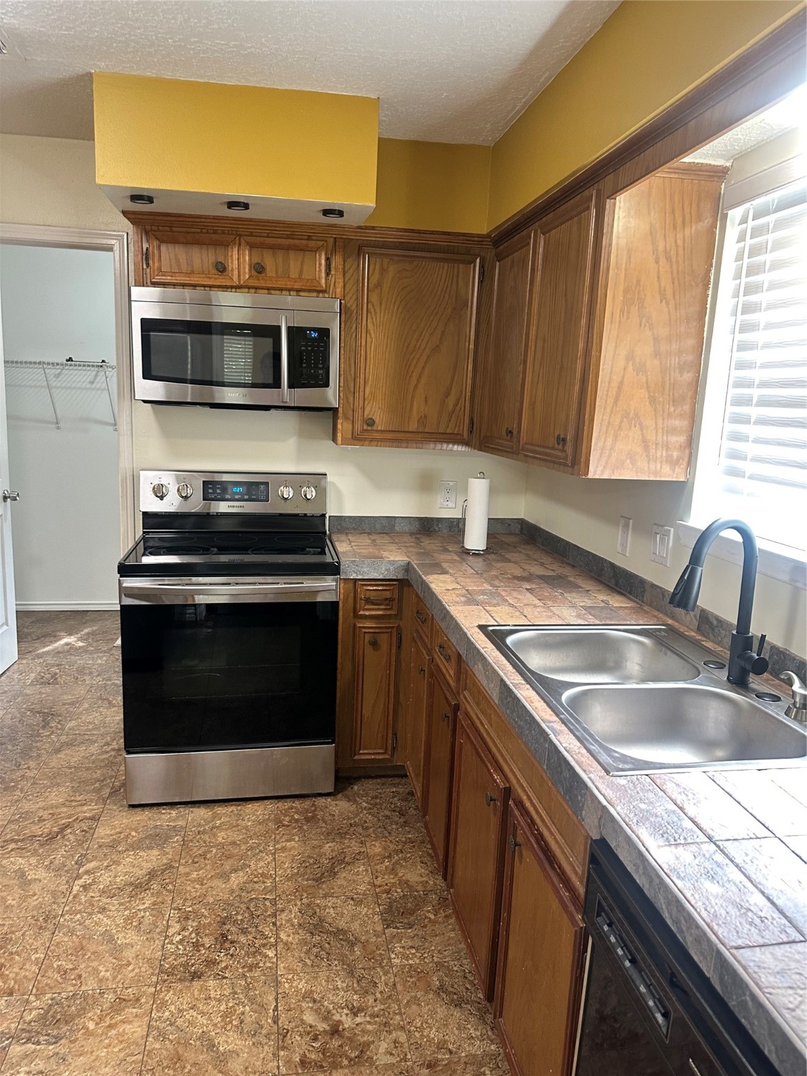 17722 Sorrell Ridge Drive Spring, TX 77388 - Photo 28 of 37 a kitchen with stainless steel appliances a stove a sink and a microwave