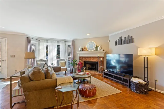 a living room with furniture a flat screen tv and a fireplace