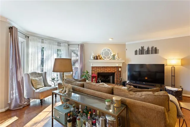 a living room with furniture a fireplace and a flat screen tv