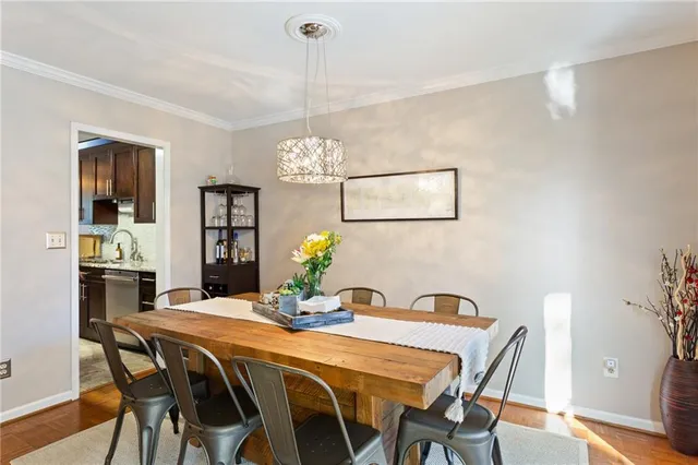 a kitchen with kitchen island granite countertop a stove top oven a sink a dining table and chairs