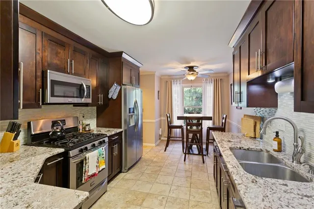 a kitchen with stainless steel appliances granite countertop a stove a sink and a microwave
