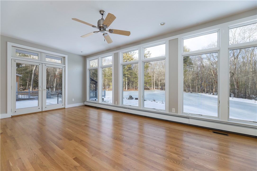 80 Browns Corner Road West Greenwich, RI 02817 - Photo 18 of 47 Living area with wood burning stove overlooking deck and pond