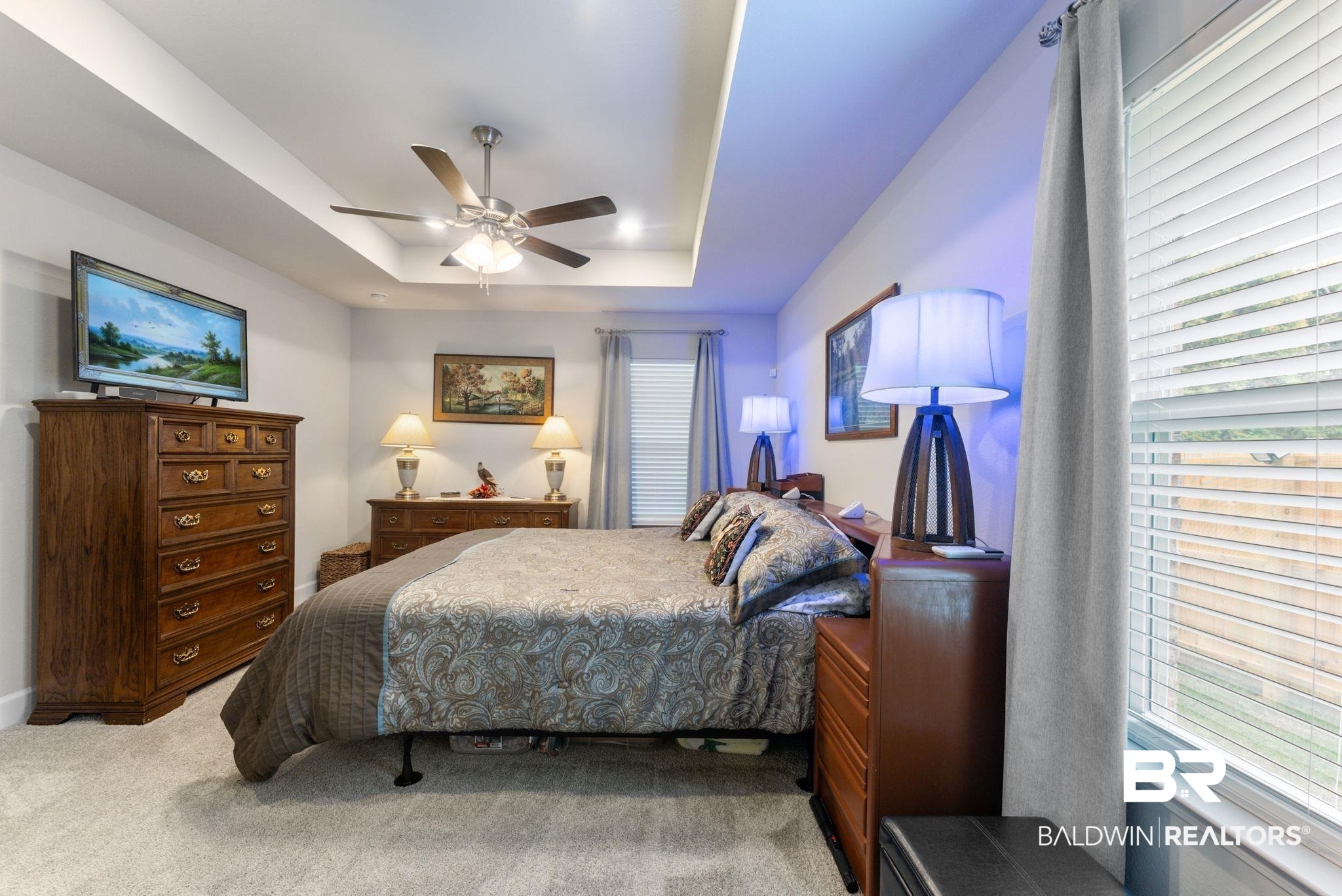 692 Mayflower Drive Foley, AL 36535 - Photo 21 of 40 Bedroom with a raised ceiling, a ceiling fan, light carpet, and multiple windows