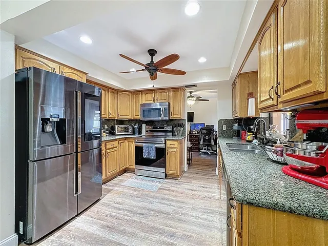 a kitchen with stainless steel appliances granite countertop a sink and cabinets