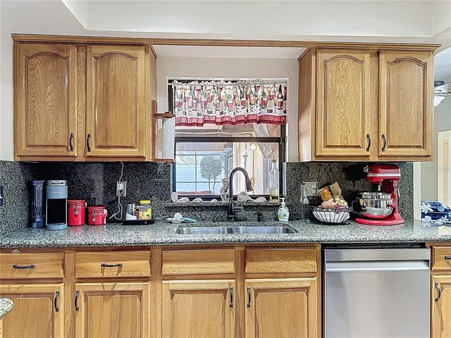 a kitchen with stainless steel appliances granite countertop a stove a sink dishwasher and cabinets with wooden floor