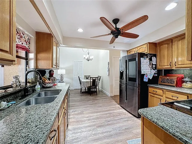 a view of a livingroom with furniture a chandelier and wooden floor