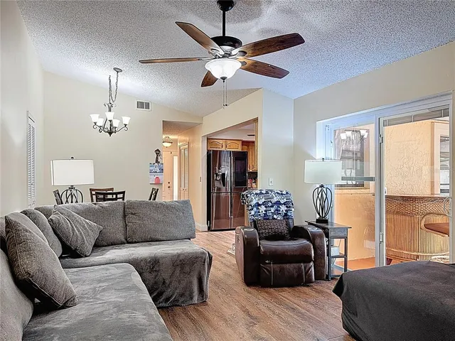 a living room with furniture ceiling fan and a window