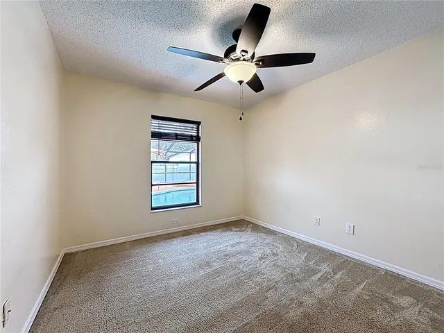 an empty room with closet and a ceiling fan