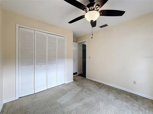 en empty room with closet and a ceiling fan