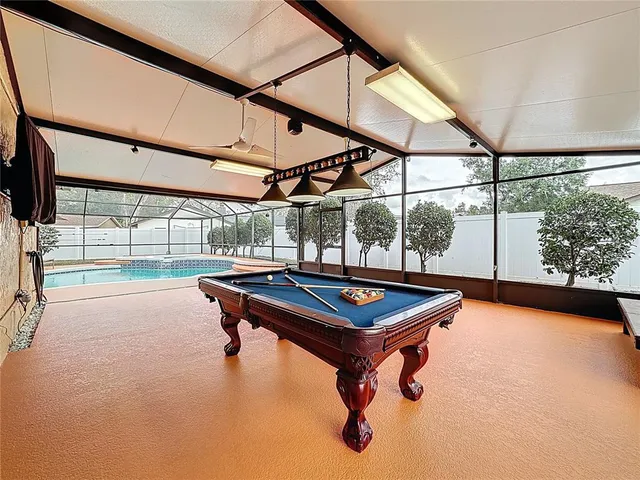 a view of a swimming pool with a patio and a yard