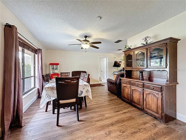 a living room with stainless steel appliances granite countertop furniture wooden floor and a window