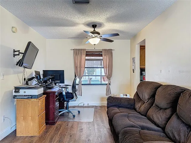 a living room with furniture a ceiling fan and a window