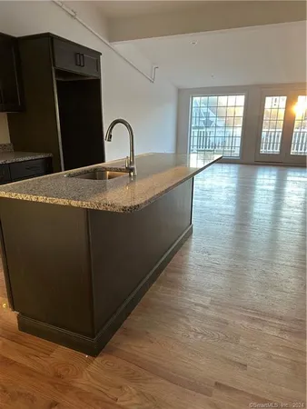 a kitchen with granite countertop a sink a stove and cabinets