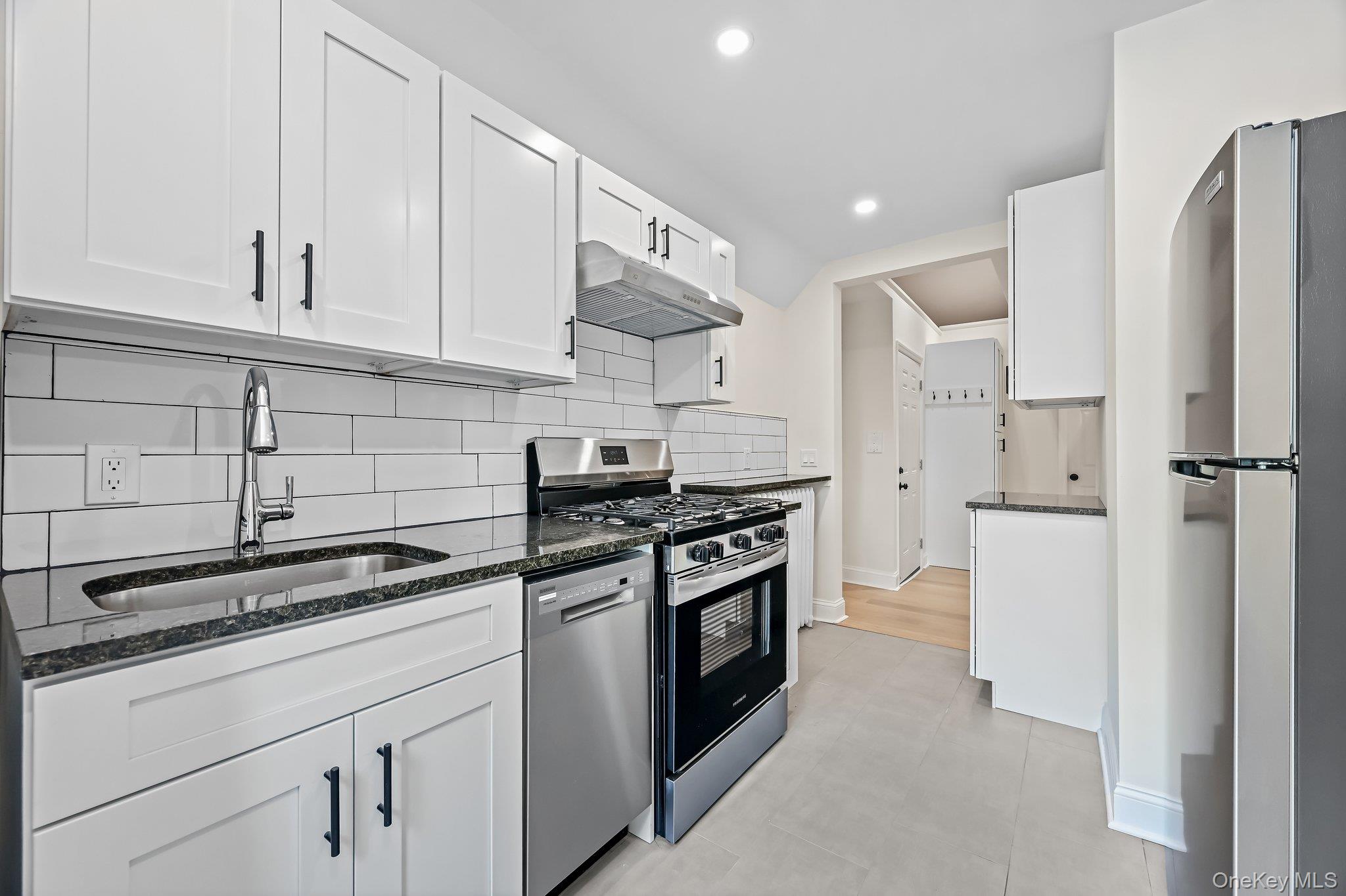12 Thomas Place, Unit 3 New Rochelle, NY 10801 - Photo 3 of 7 a kitchen with stainless steel appliances granite countertop a sink a stove a refrigerator and white cabinets