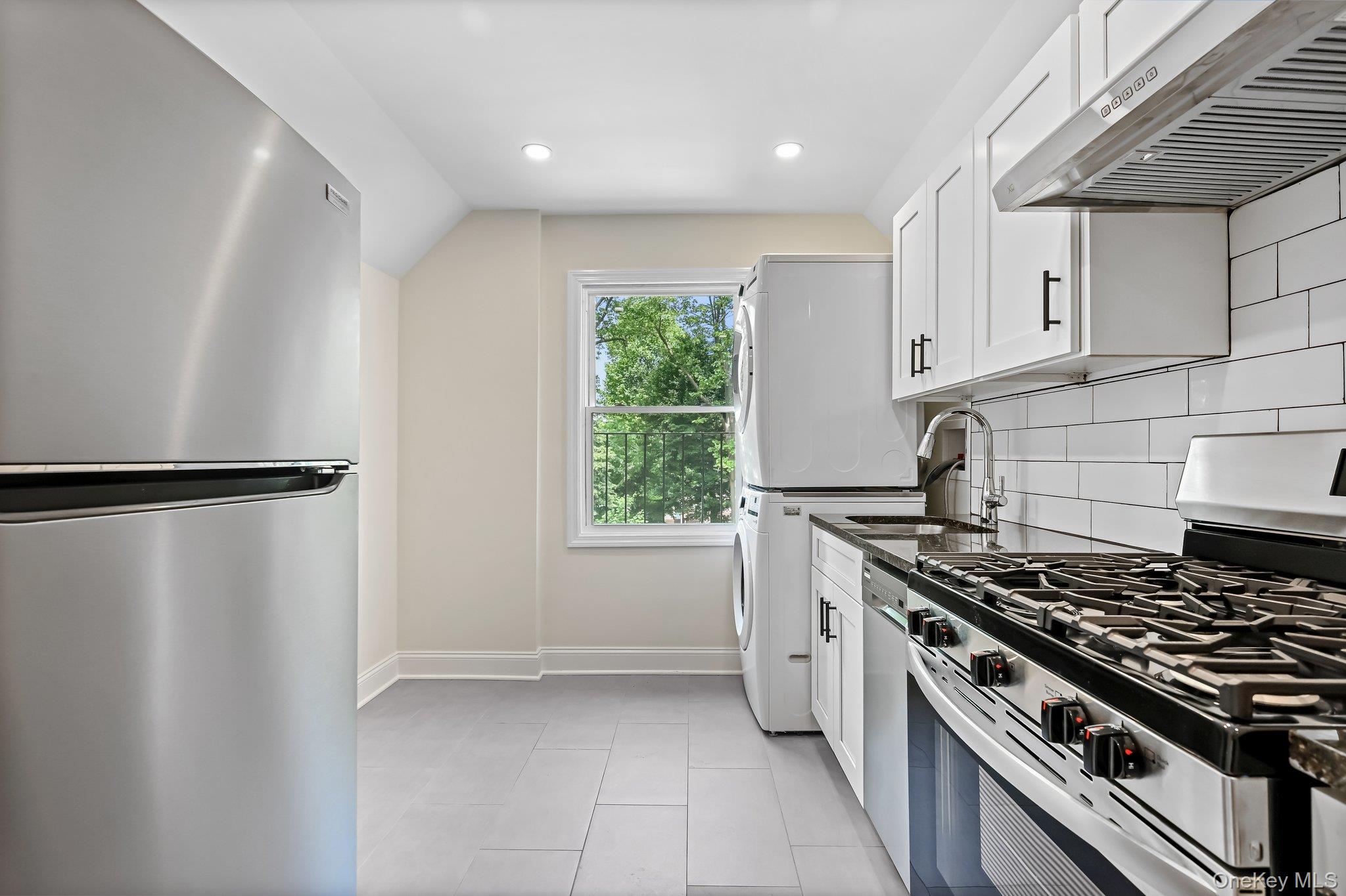 12 Thomas Place, Unit 3 New Rochelle, NY 10801 - Photo 4 of 7 a kitchen with stainless steel appliances a stove a refrigerator and a window