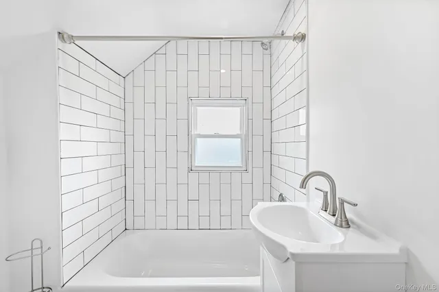 a bathroom with a sink a shower and a bathtub