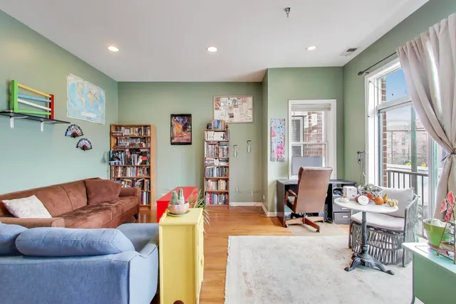 a living room with furniture kitchen view and a large window