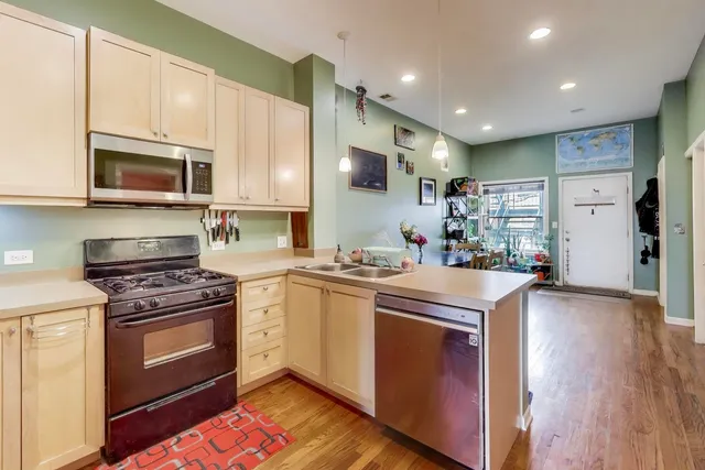 a kitchen with stainless steel appliances granite countertop a stove a sink and a microwave