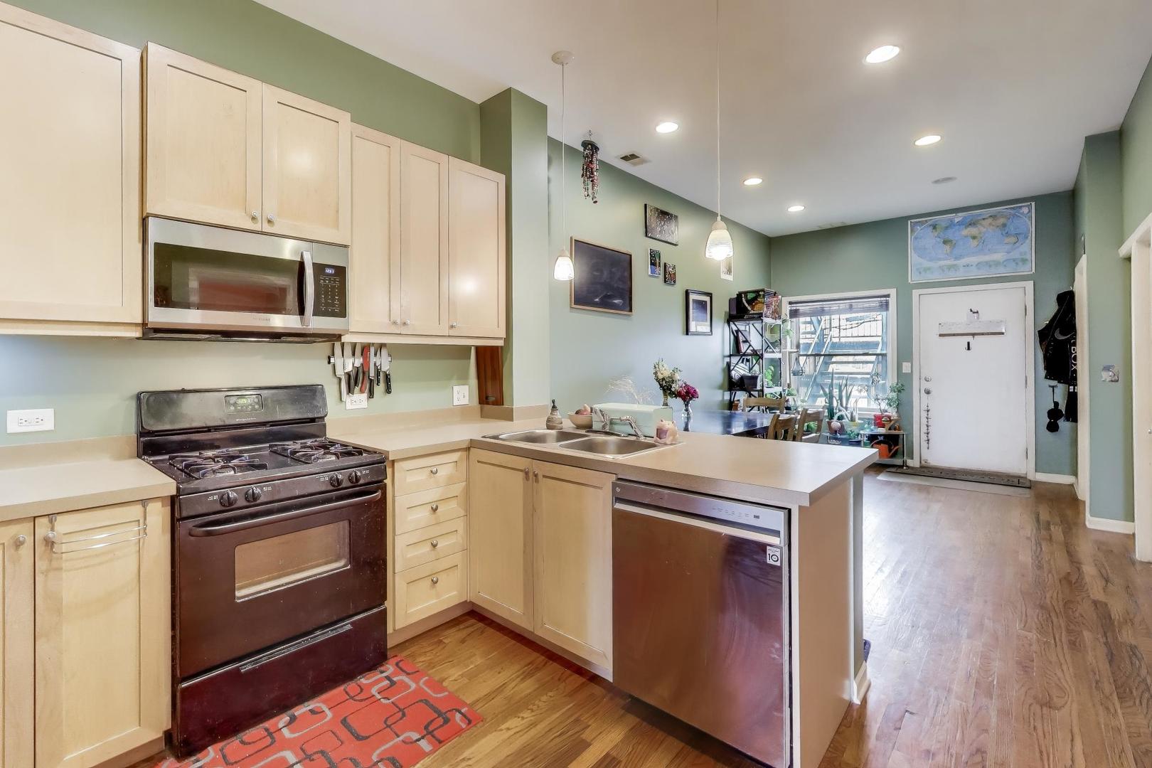 2451 South Western Avenue, Unit 2S Chicago, IL 60608 - Photo 5 of 16 a kitchen with stainless steel appliances granite countertop a stove a sink and a microwave