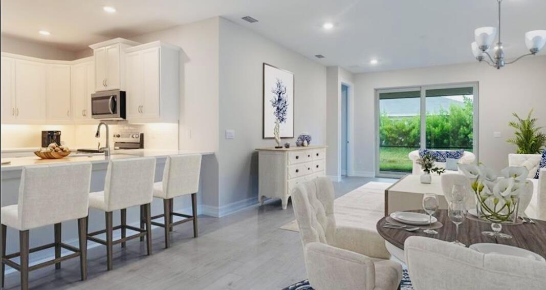 911 Enbrook Loop Naples, FL 34114 - Photo 3 of 20 a dining room with furniture a window and a kitchen view