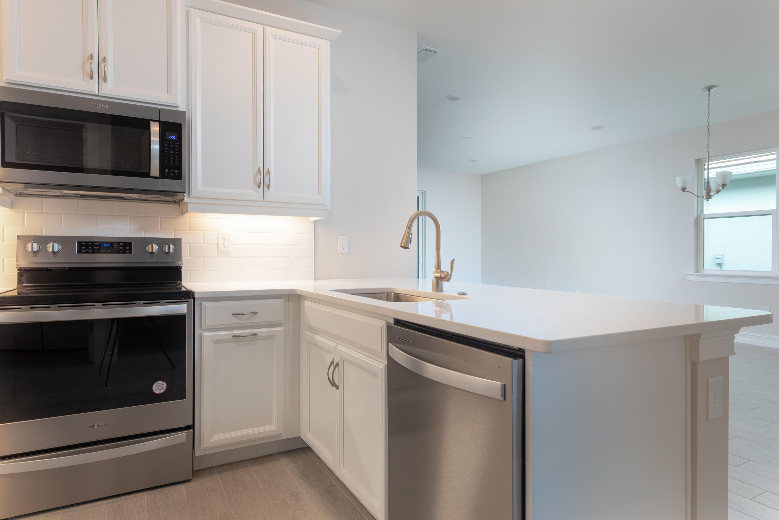 911 Enbrook Loop Naples, FL 34114 - Photo 7 of 20 a kitchen with sink a microwave and stove