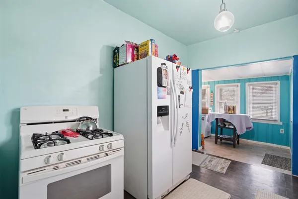 a kitchen with a refrigerator and a stove top oven