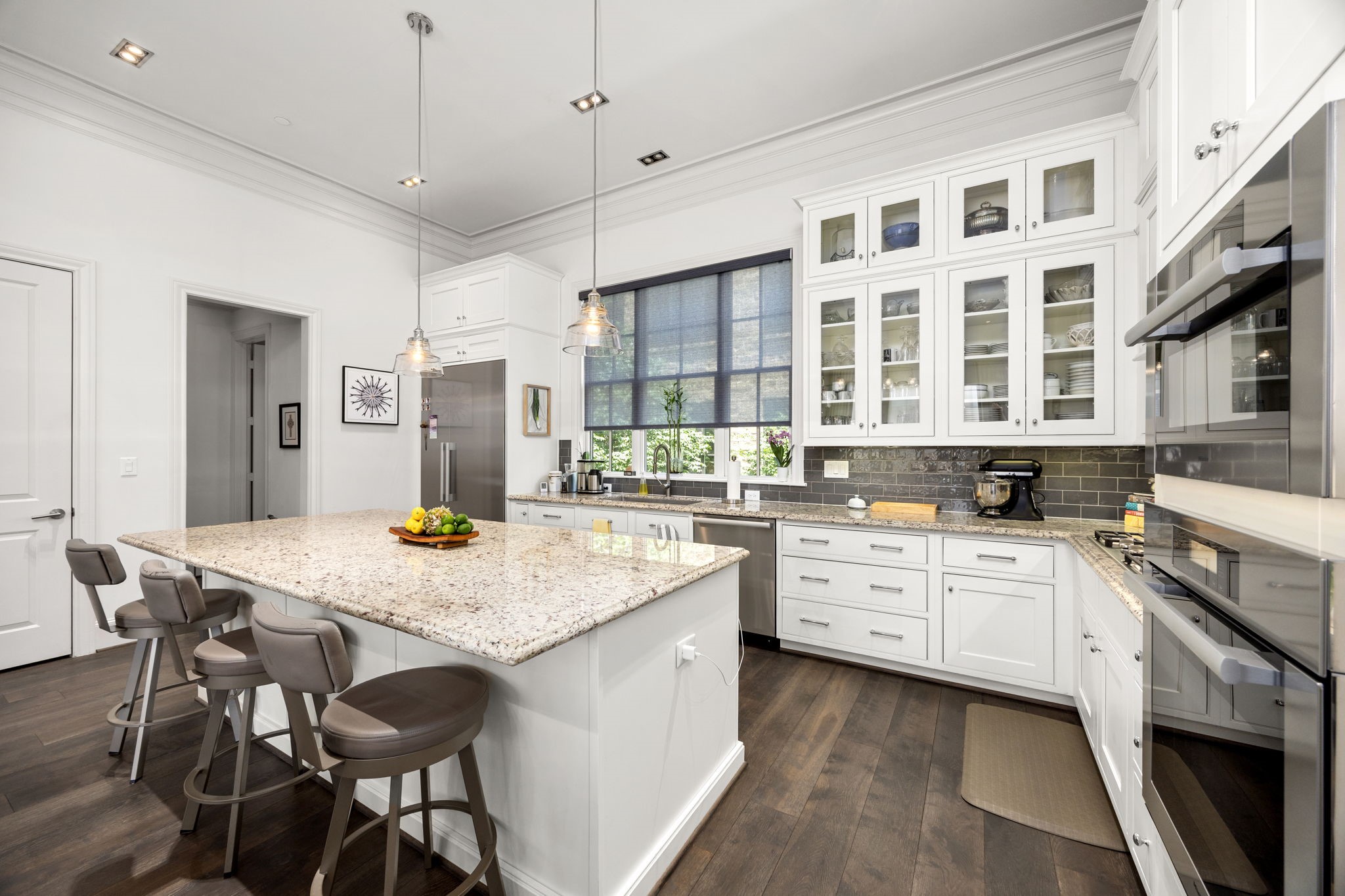 11 Robita Street Houston, TX 77019 - Photo 15 of 32 a kitchen with stainless steel appliances kitchen island granite countertop a table chairs in it and white cabinets