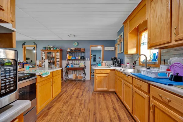 a kitchen with stainless steel appliances wooden floor a sink and a large window