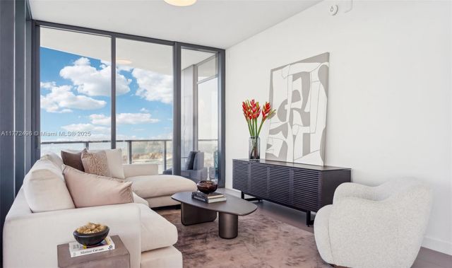 a living room with furniture and a floor to ceiling window