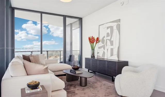 a living room with furniture and a floor to ceiling window