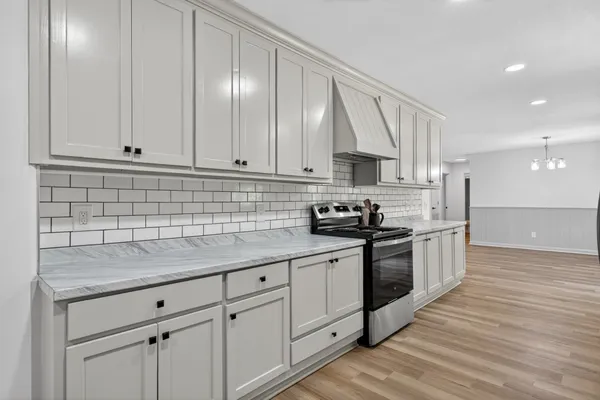 a kitchen with stainless steel appliances granite countertop a sink a stove and cabinets
