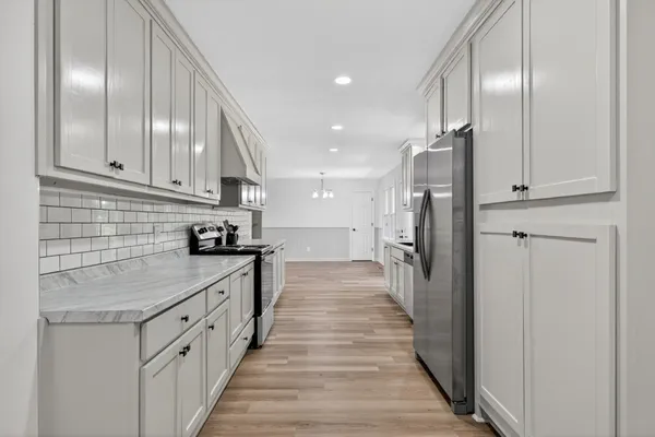 a kitchen with kitchen island granite countertop lots of counter top space and stainless steel appliances