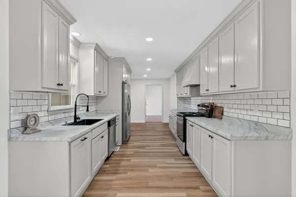a kitchen with stainless steel appliances granite countertop a sink stove and cabinets