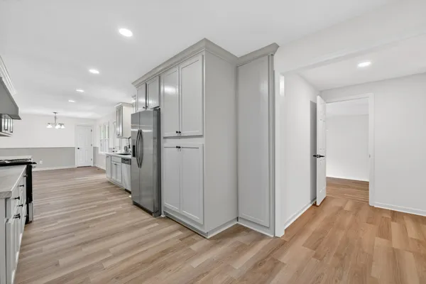 a view of a kitchen with wooden floor and a refrigerator