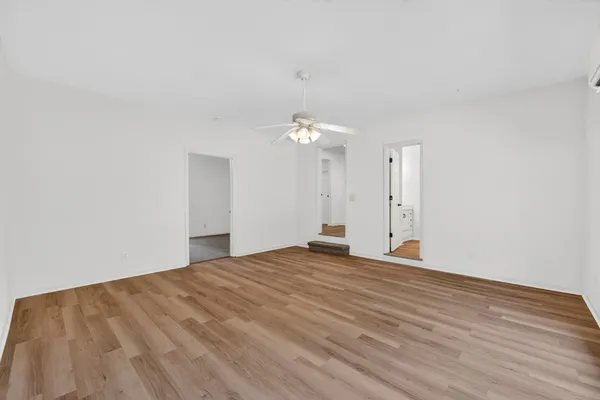 a view of a big room with wooden floor and a ceiling fan