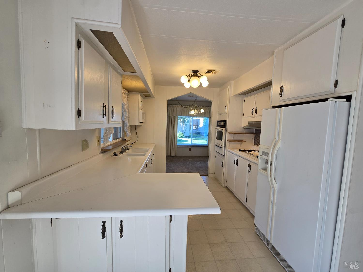 233 Apple Lane Rohnert Park, CA 94928 - Photo 11 of 17 a kitchen with refrigerator cabinets and wooden floor