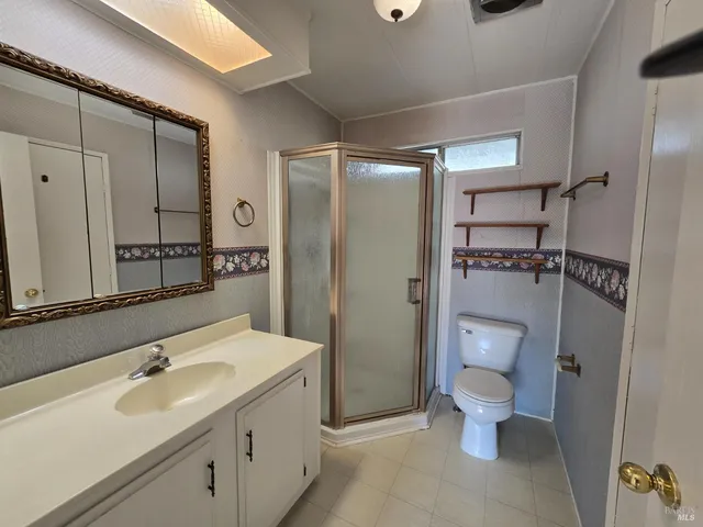 a bathroom with a granite countertop sink toilet and shower