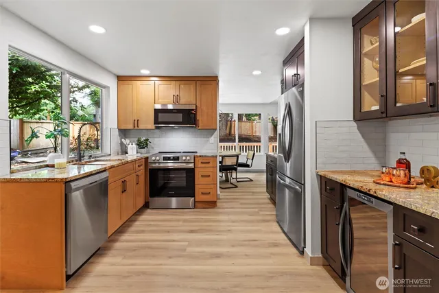 a kitchen with stainless steel appliances kitchen island granite countertop a stove a sink dishwasher and a refrigerator