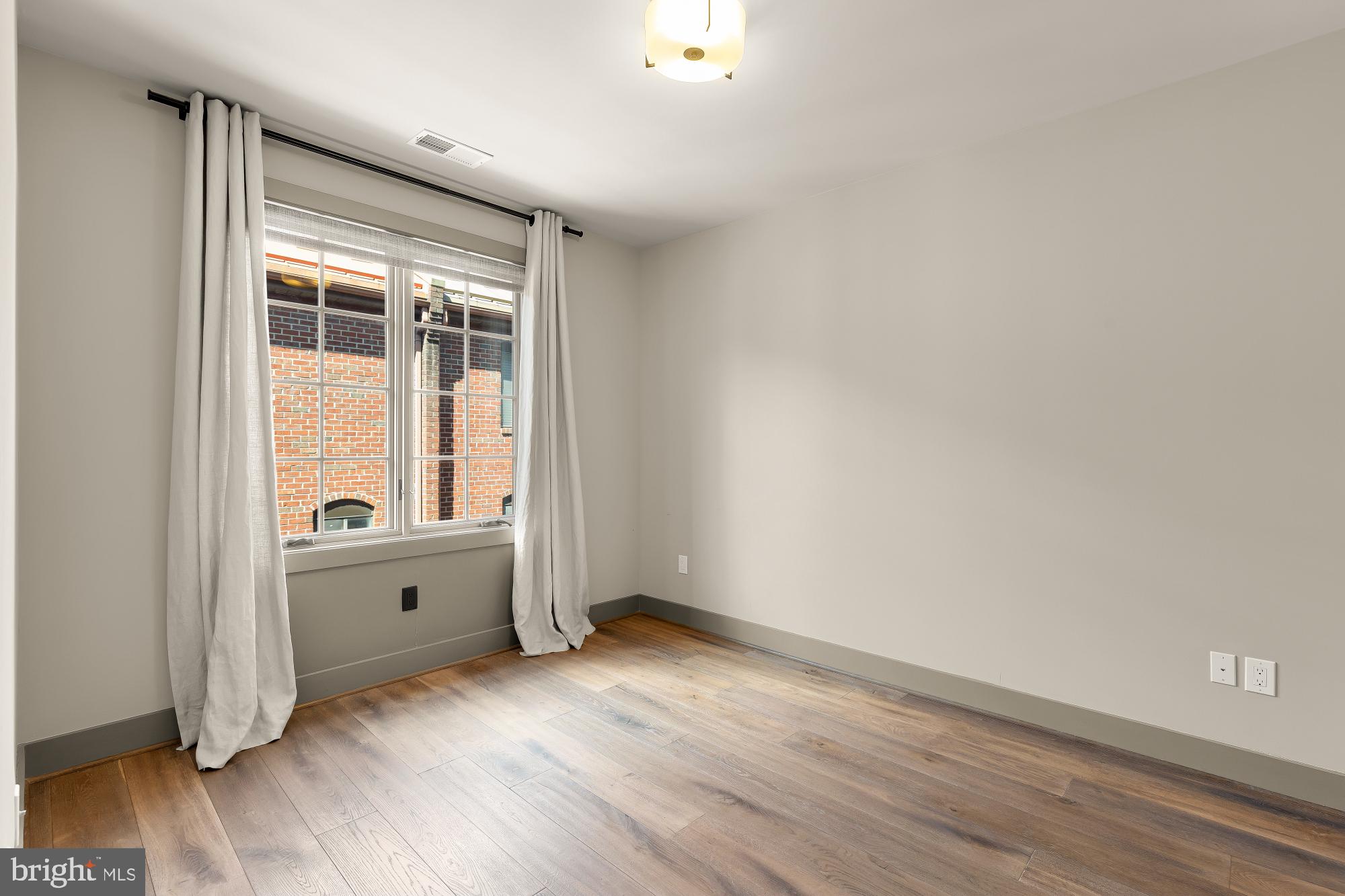3220 Grace Street Northwest, Unit 5 Washington, DC 20007 - Photo 16 of 31 an empty room with wooden floor and windows
