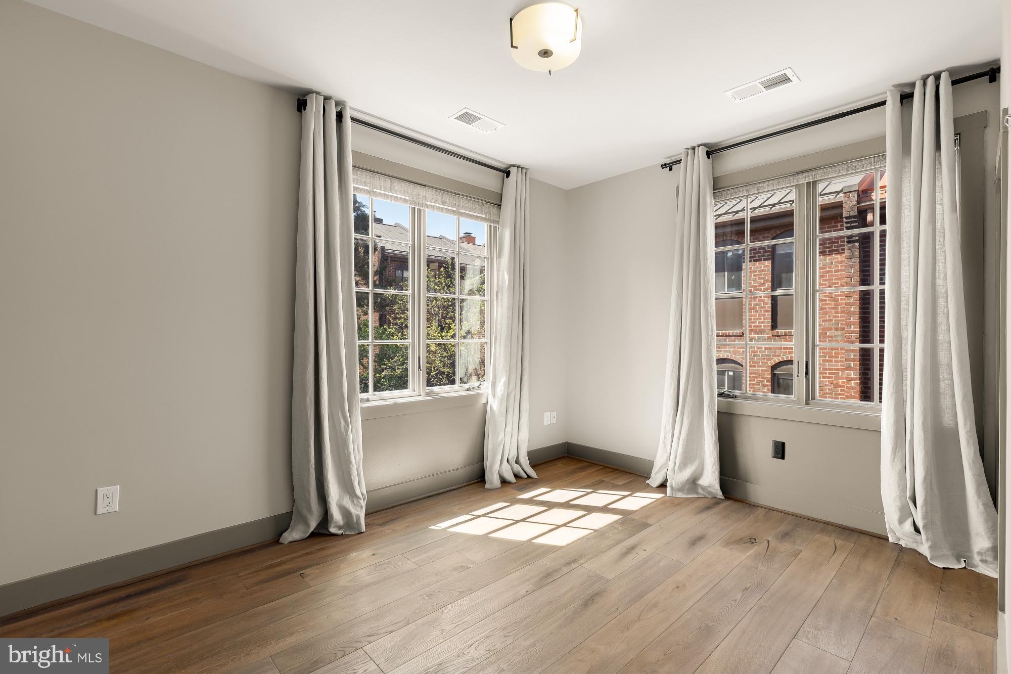 3220 Grace Street Northwest, Unit 5 Washington, DC 20007 - Photo 21 of 31 an empty room with wooden floor and windows