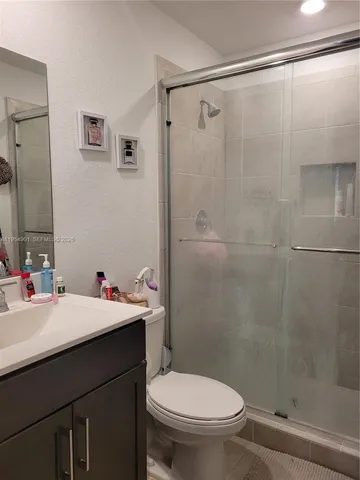 a bathroom with a sink mirror and a toilet