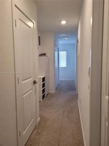 a view of a hallway with closet and wooden floor