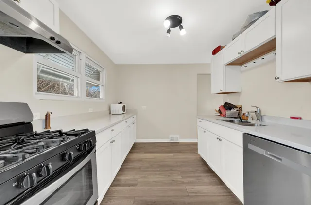 a kitchen with stainless steel appliances a sink stove and cabinets