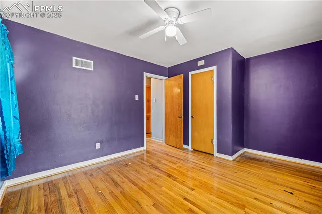 a view of empty room with window and ceiling fan
